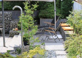 Garten für Ästheten mit Liegestühlen, Gartendusche und Gabionen