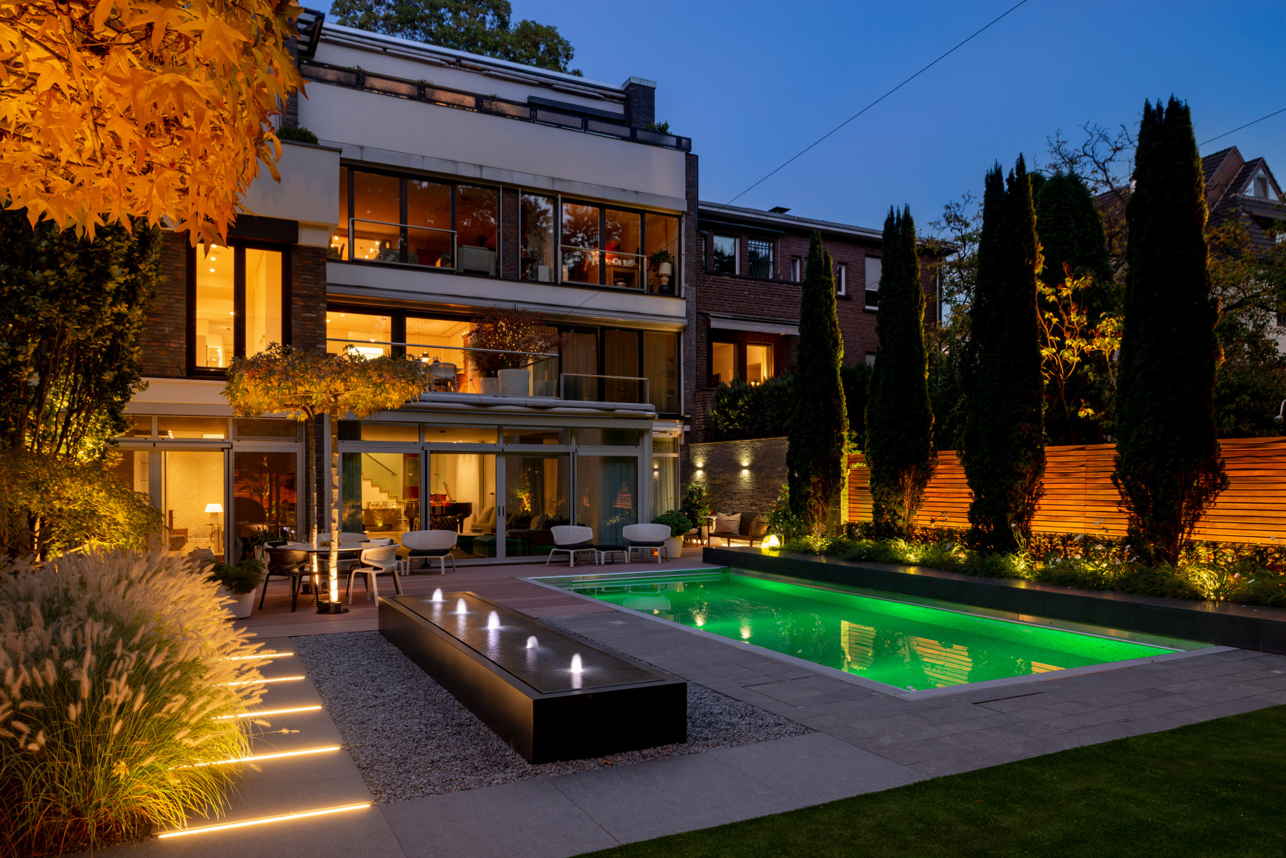 Ergebnis einer Lichtplanung: Garten mit Pool mit atmosphärischer Beleuchtung in den Abendstunden